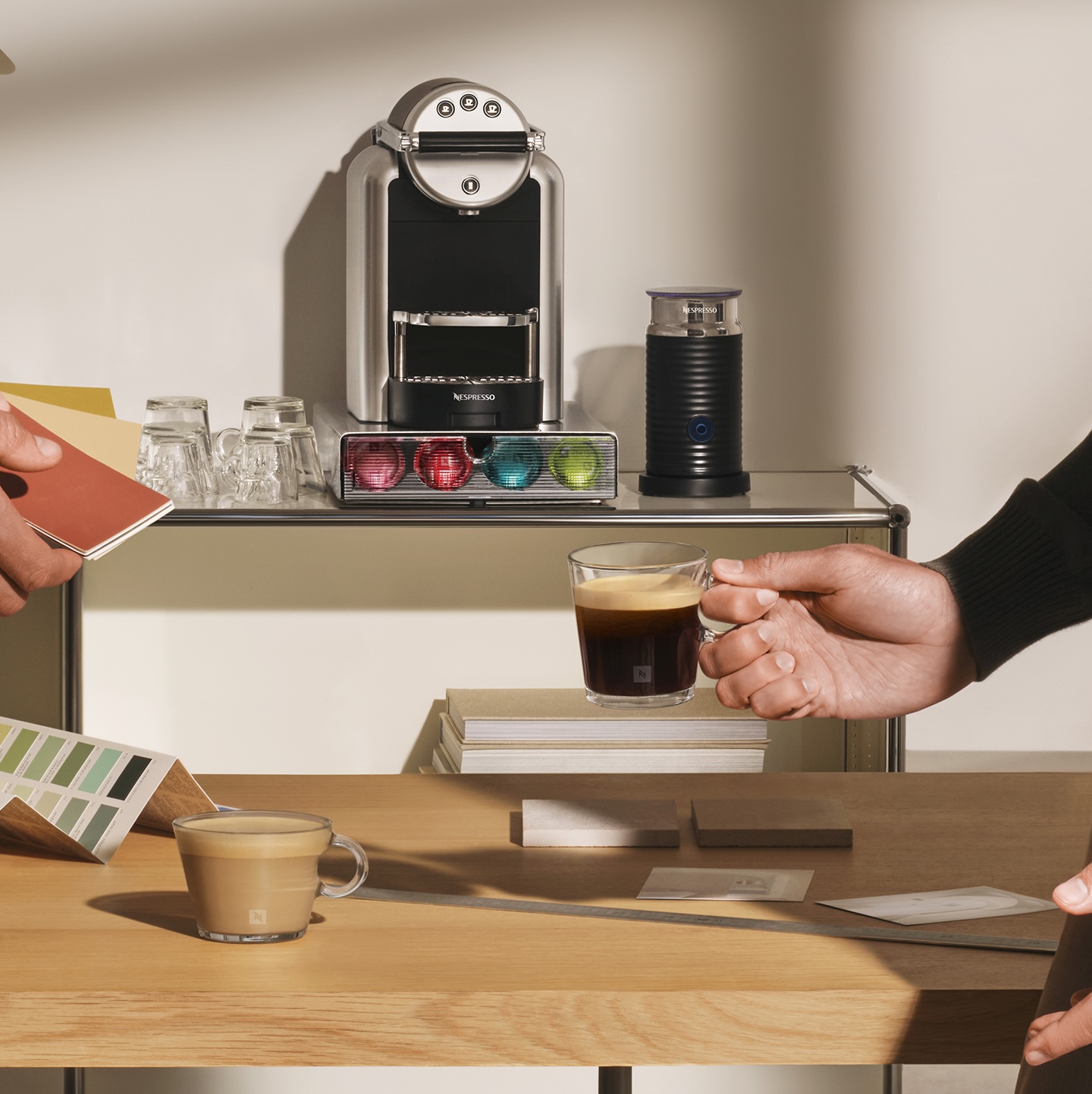 Nespresso Zenius kávégép előtt egy férfi egy csésze espresso-t nyújt